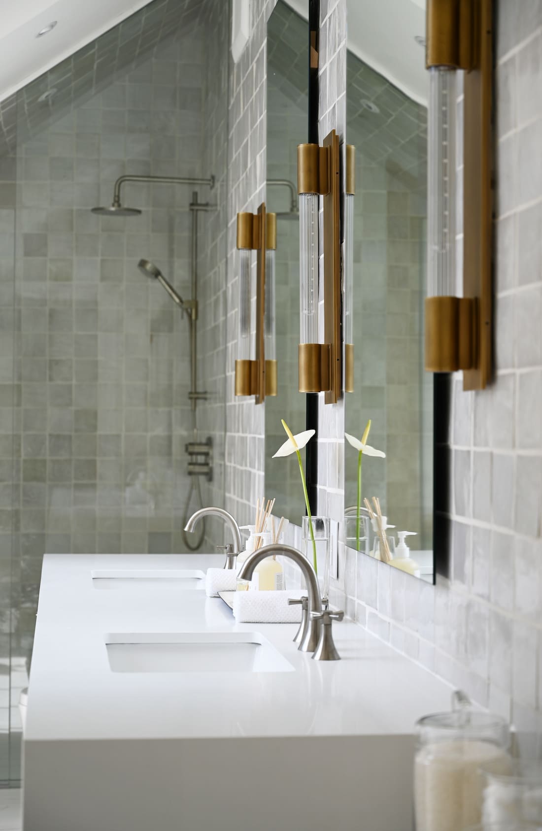 Brass baton wall scones above white vanity