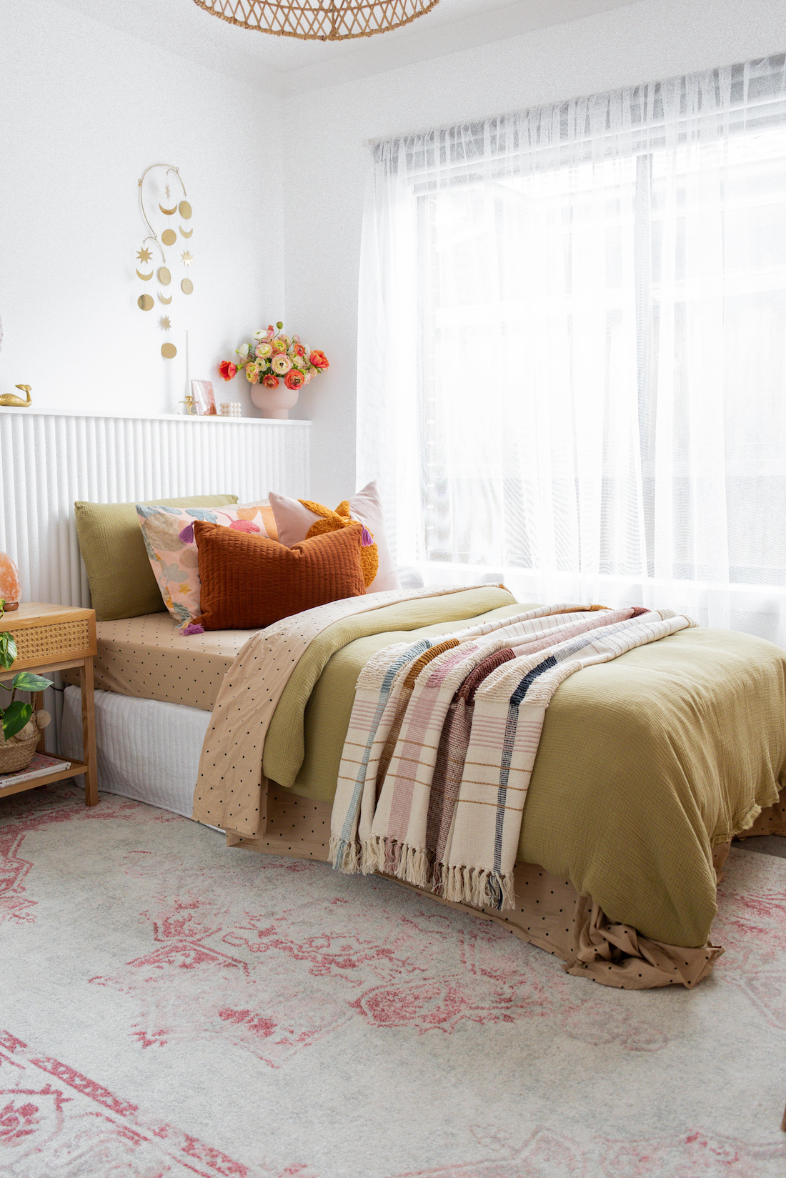 Olive green bedding in young girls bedroom styling above a bed