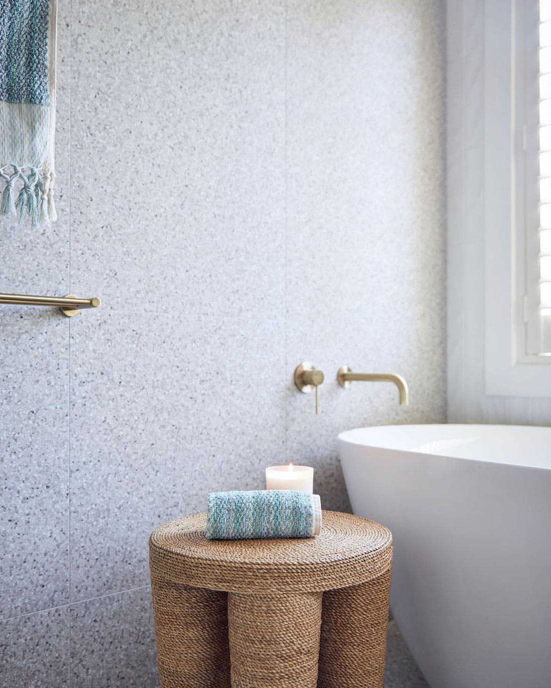 Freestanding bath with terrazzo look tiled wall