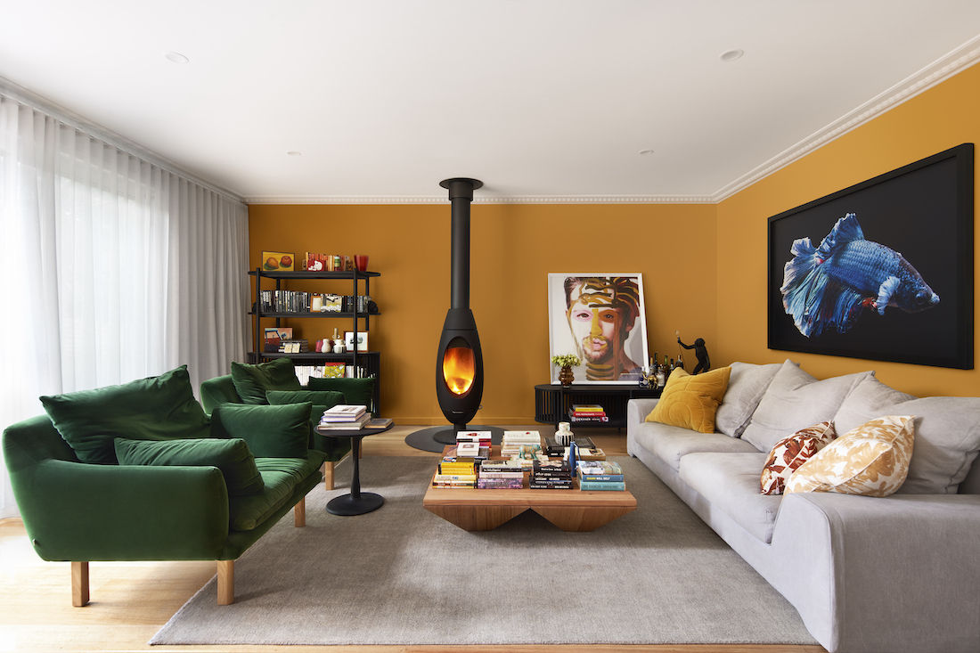 Mustard walls in living room with green sofas