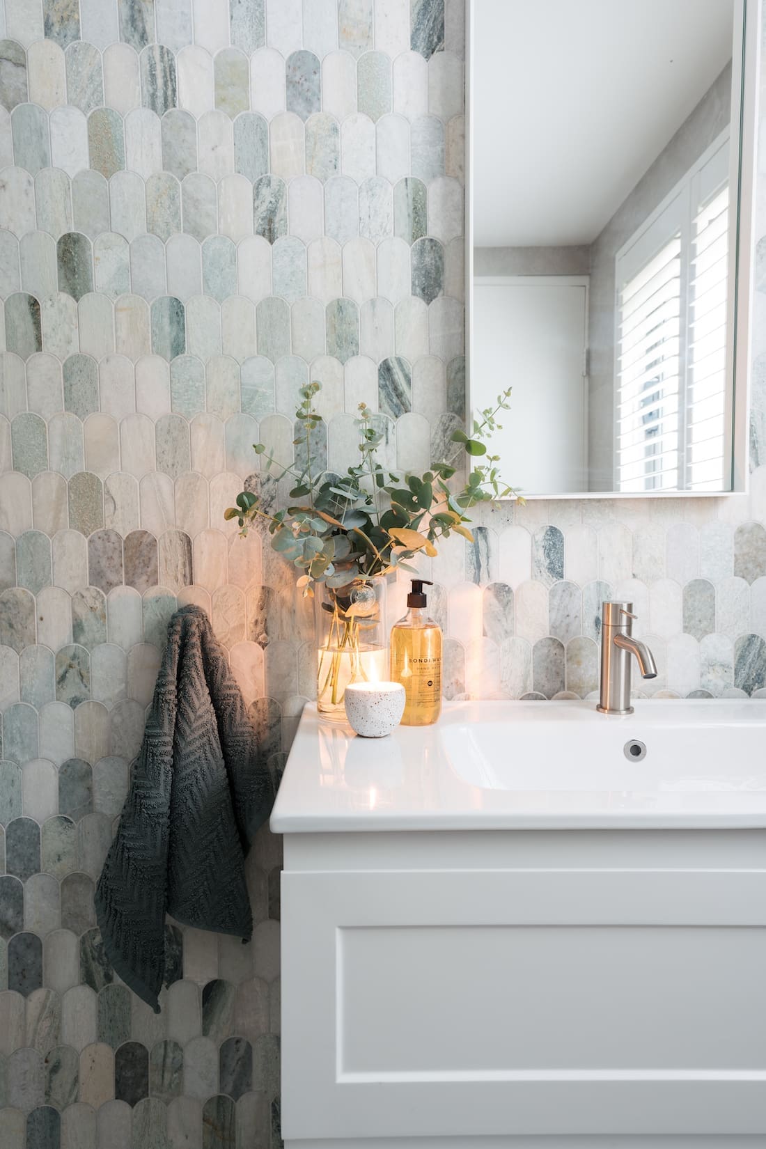 Styled contemporary bathroom with green marble feature tile