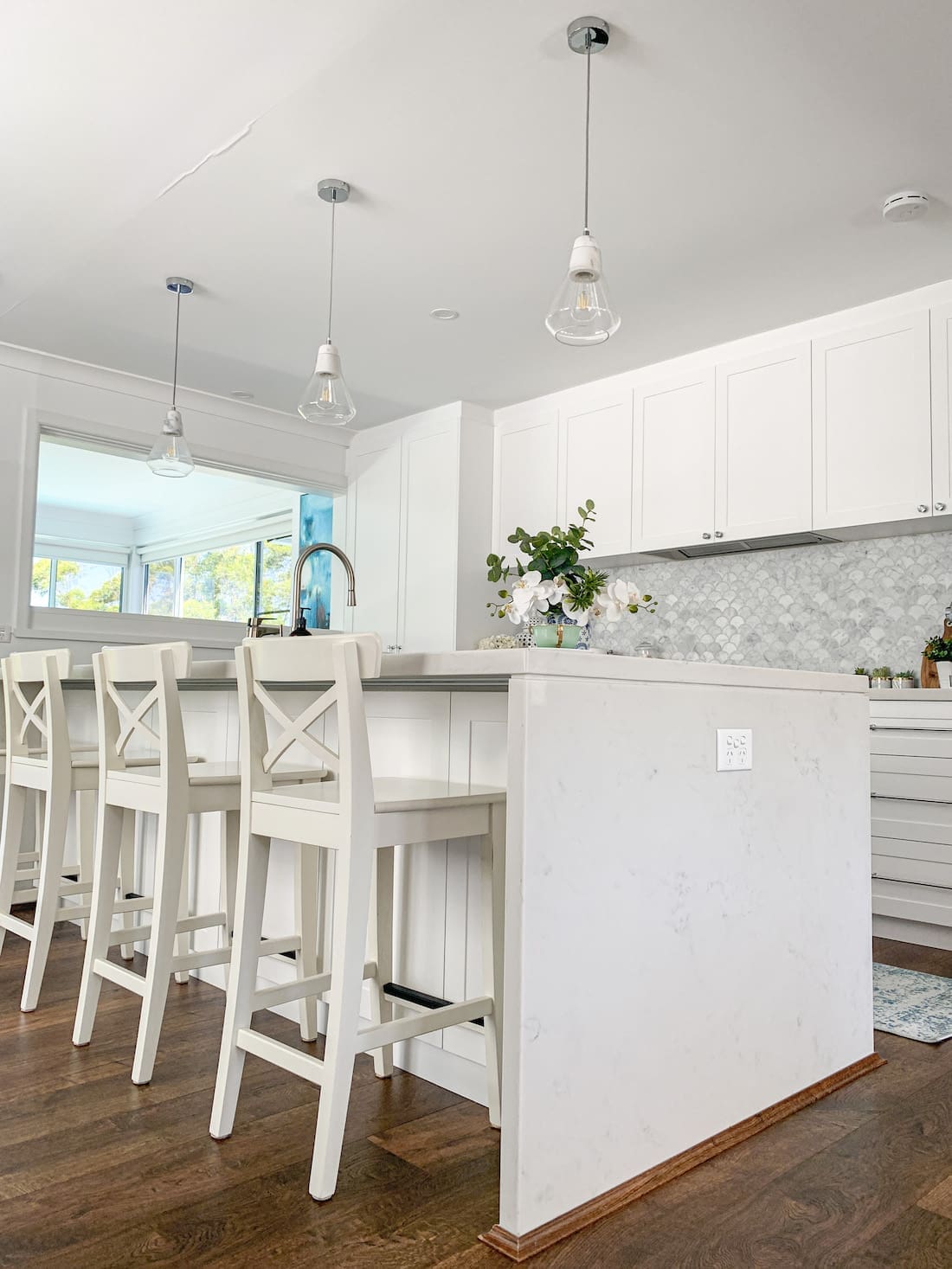 White kitchen bench with white bar stools