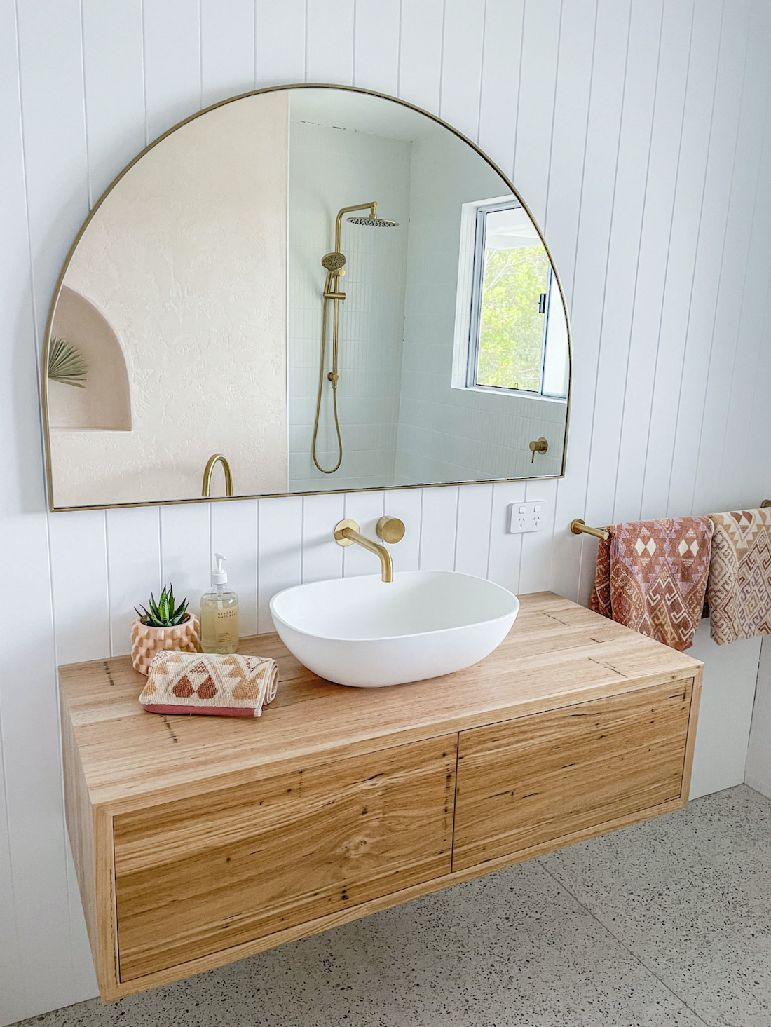 timber vanity with arched wall mirror