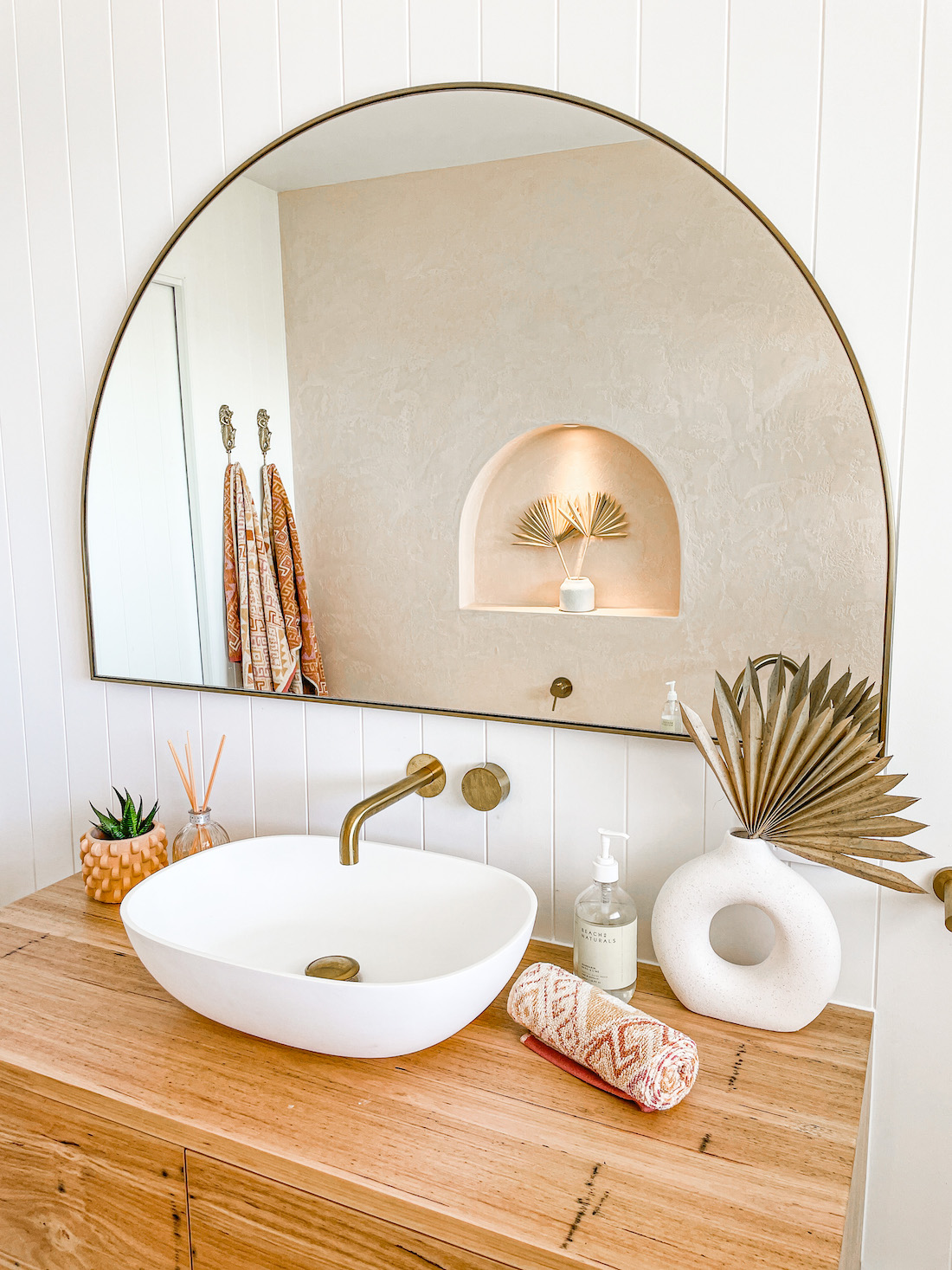 timber vanity with white basin and arch mirror _ earthy coastal bathroom