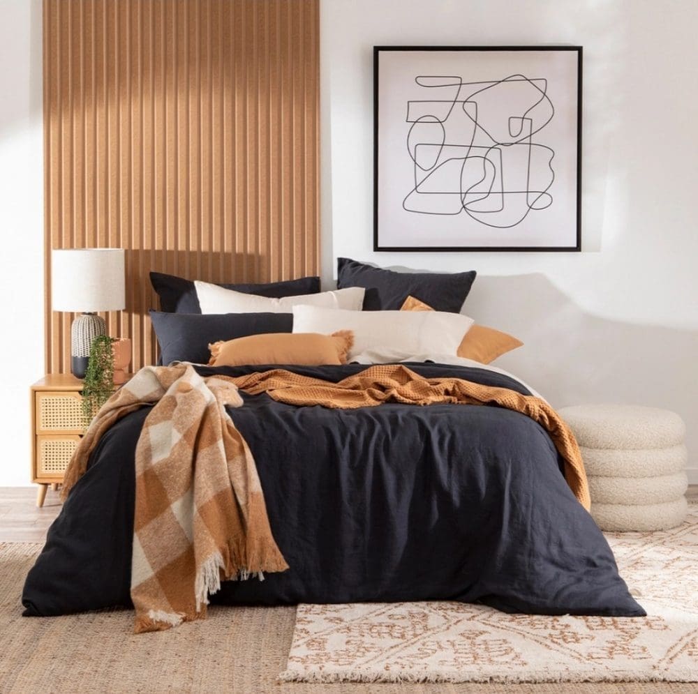 Navy bedding in masculine bedroom with half panelled feature wall