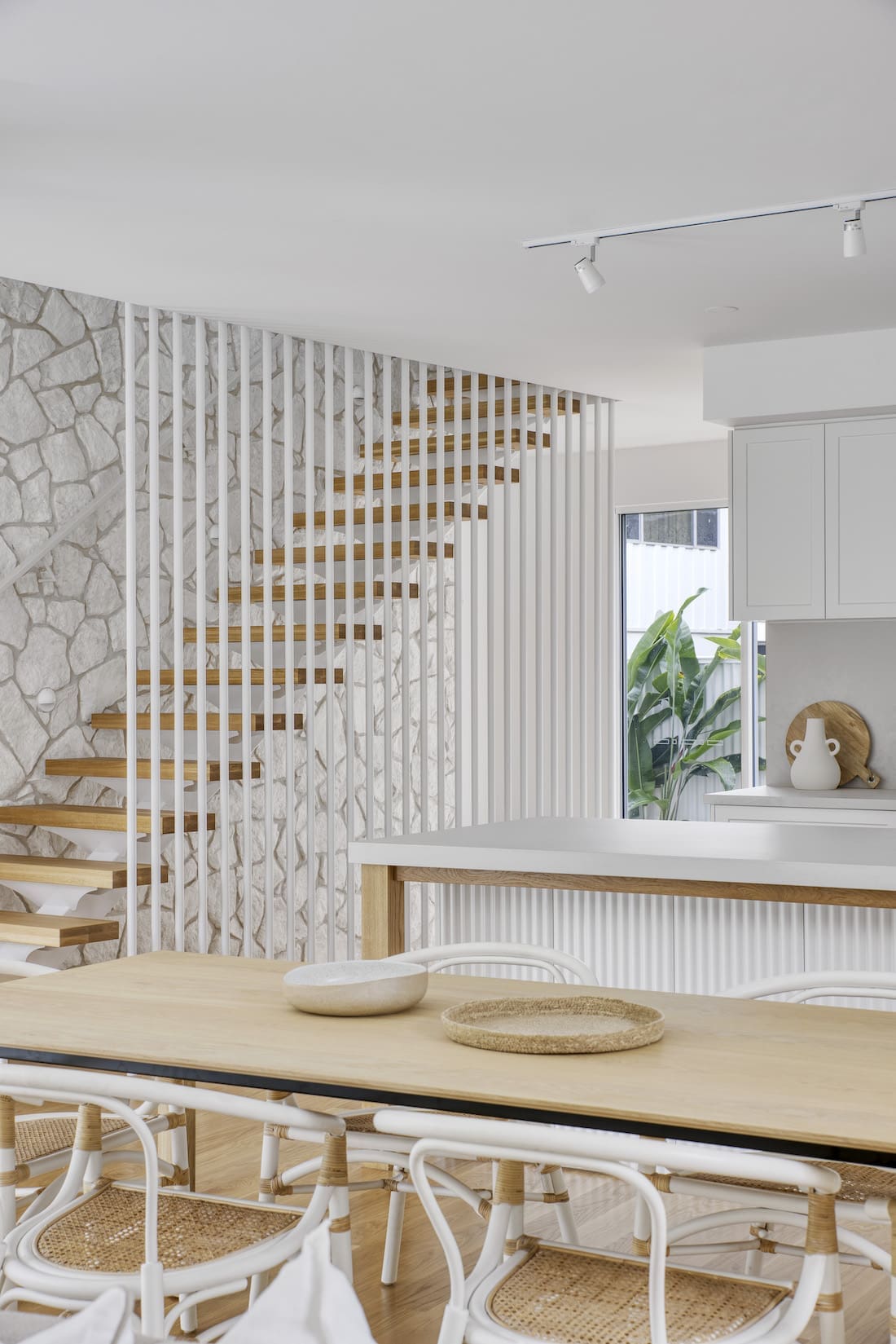 White batons against stone wall and timber tread stairs at Tawarri house