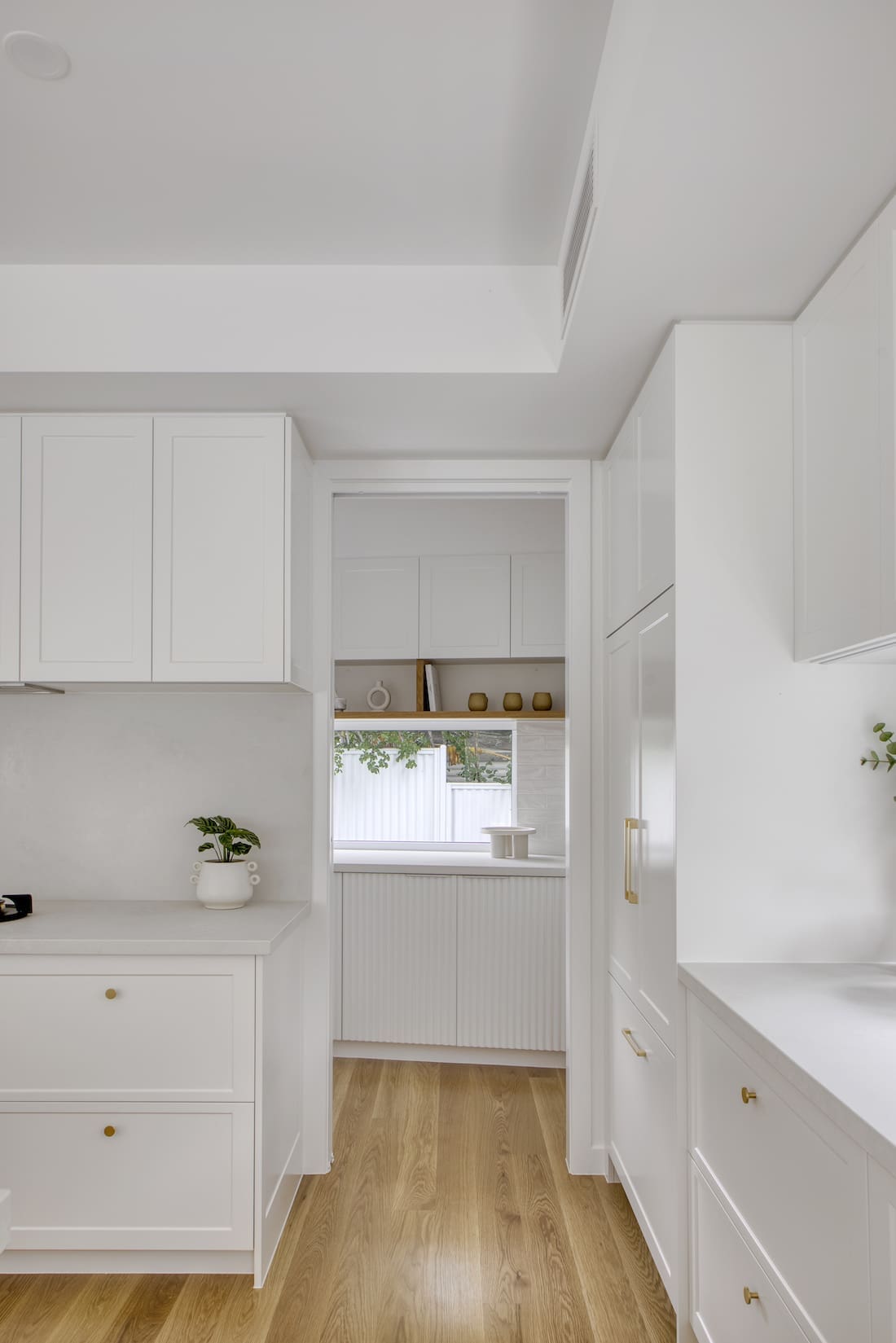 White pantry with timber floors in Tawarri house