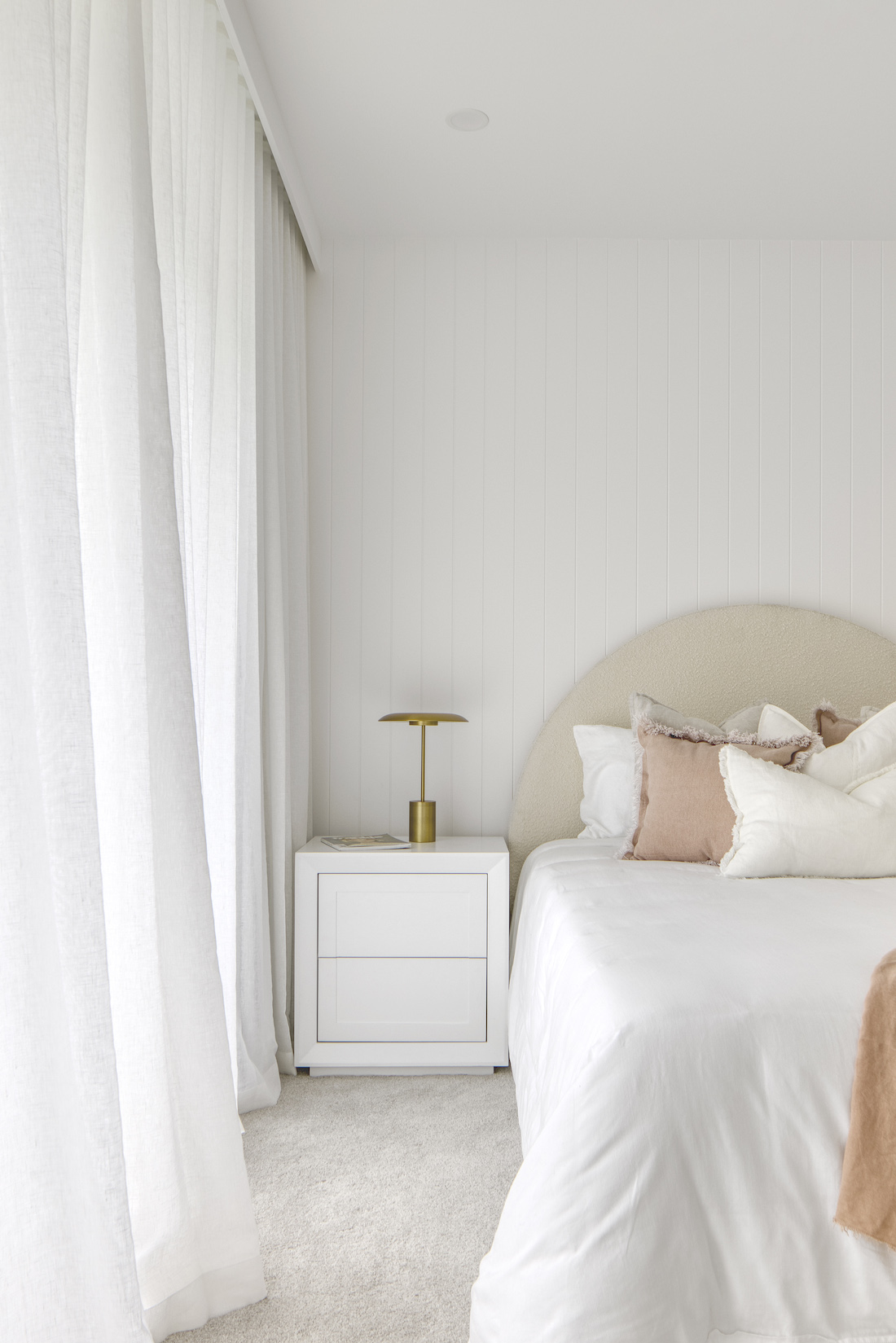 White bedroom with curved bedhead at Tawarri house