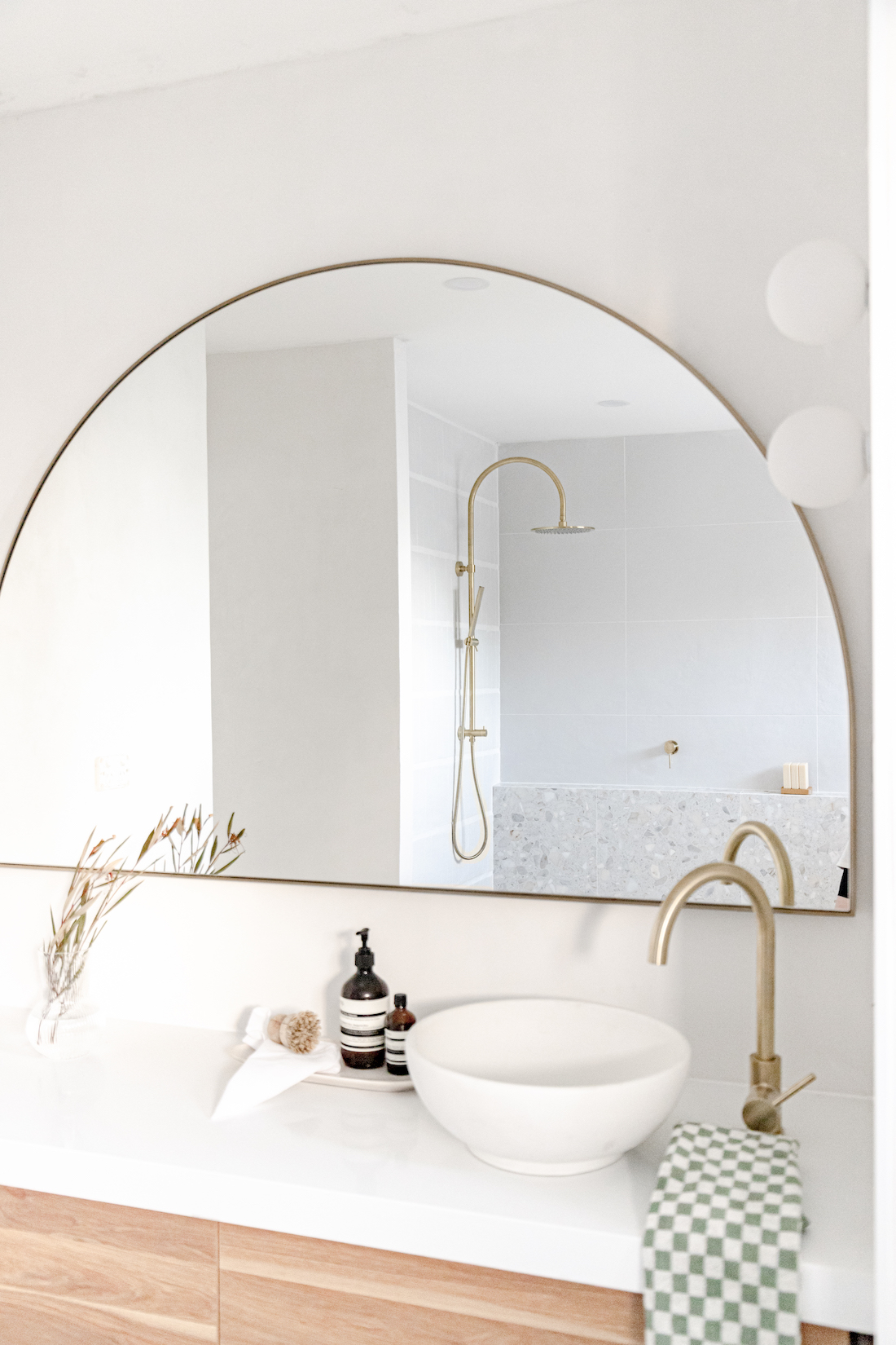 Curved gold bathroom mirror