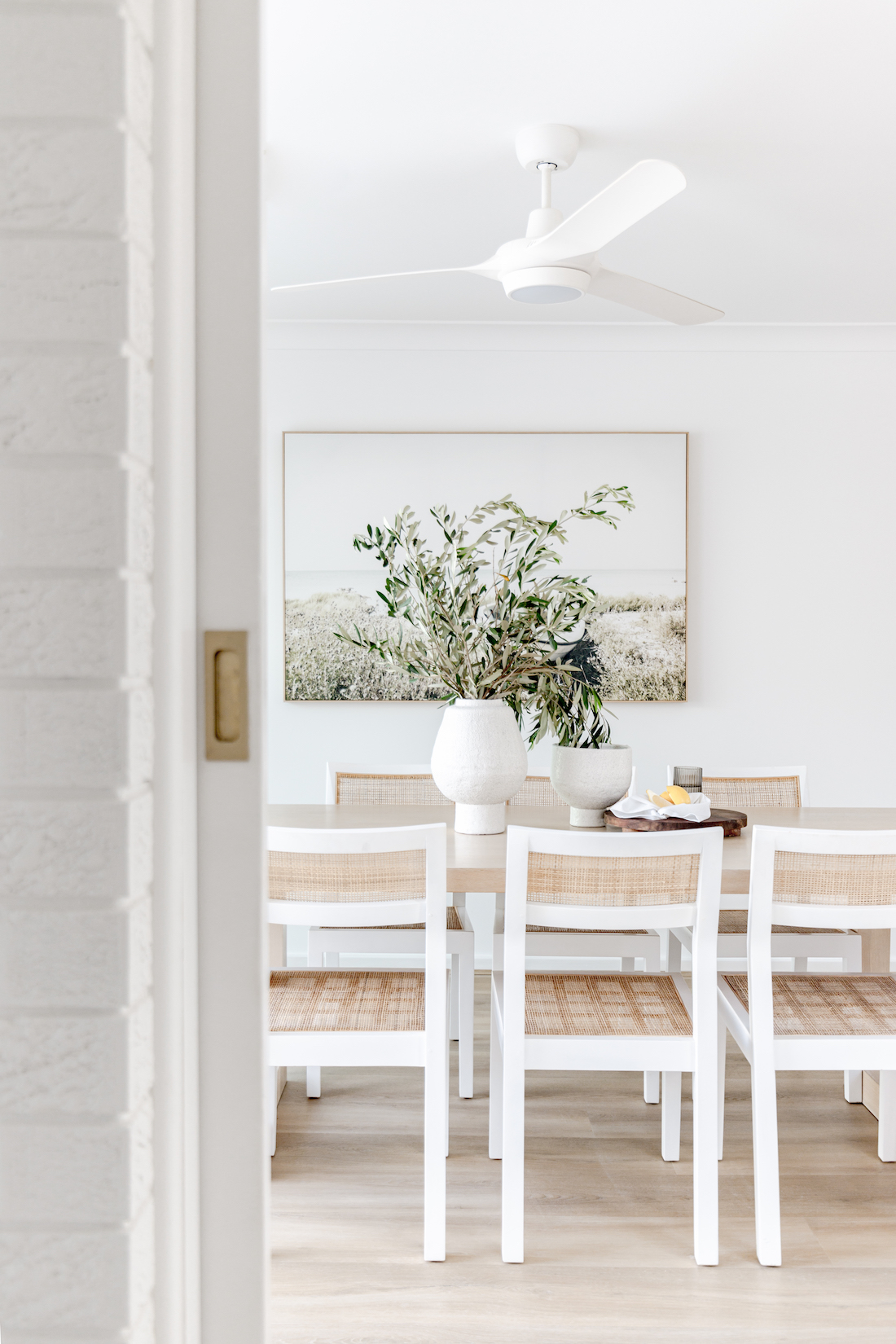Dining room with white and rattan dining chairs
