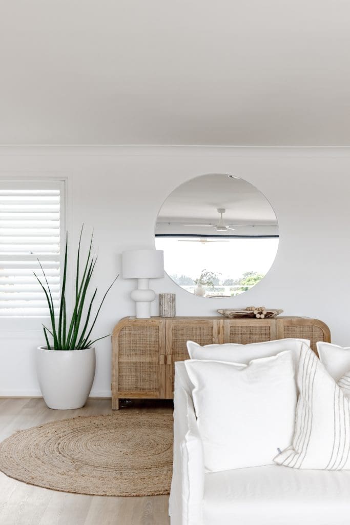 Coastal living room with round mirror