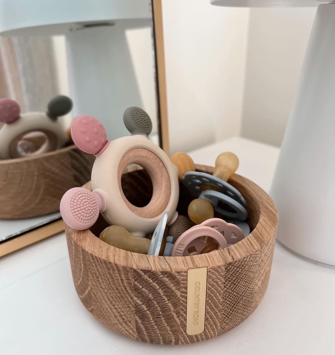 Wooden bowl with baby toys and dummies