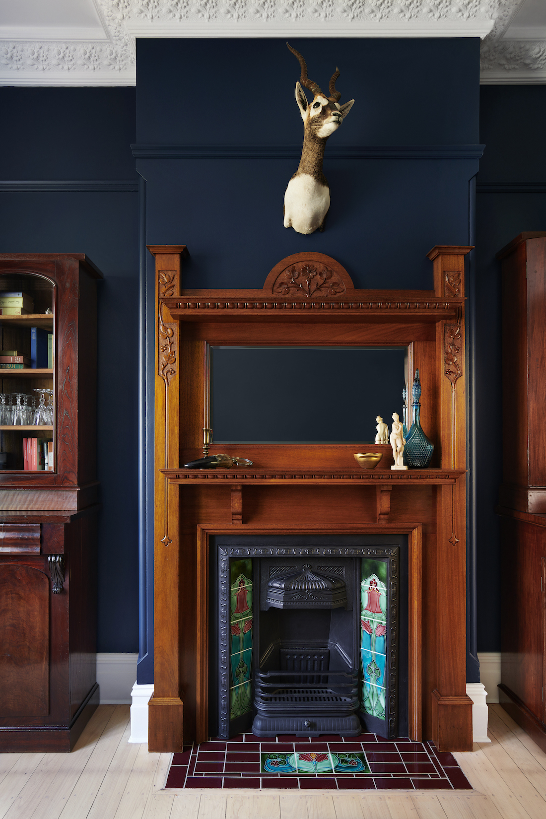 Original timber fireplace mantle in dark painted room by The Stylesmiths