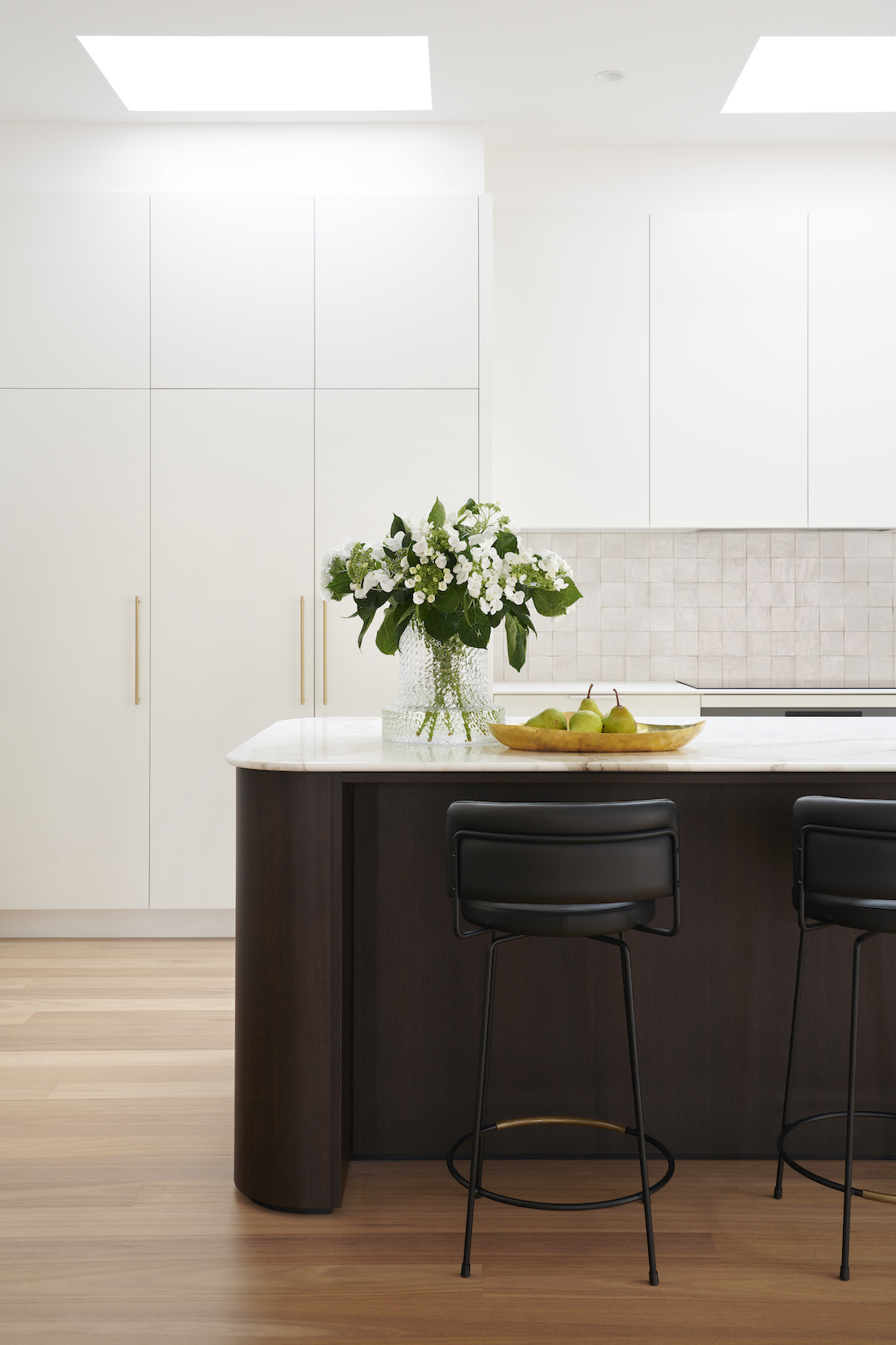 Dark island with white cabinetry by The Stylesmiths