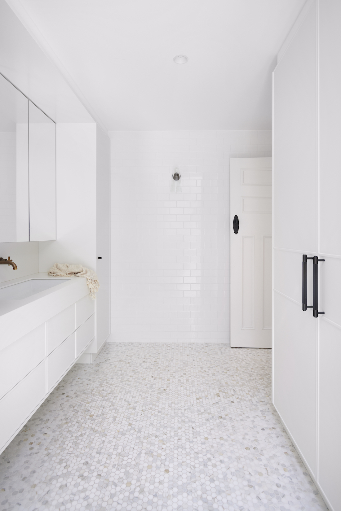 White on white space with penny round tiles by The Stylesmiths