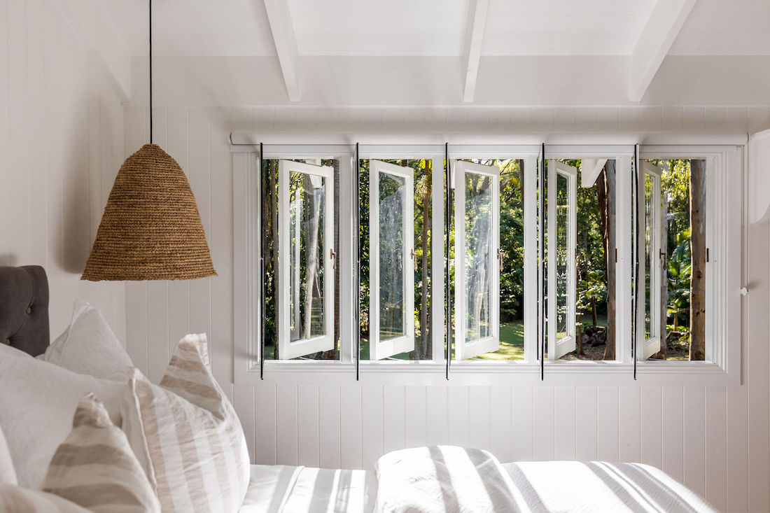 Bedroom with windows opening out to gardens at Fig Tree Villa Byron Bay