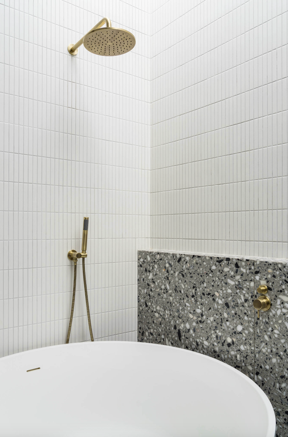 Round bath tub white kitkat tiles and terrazzo