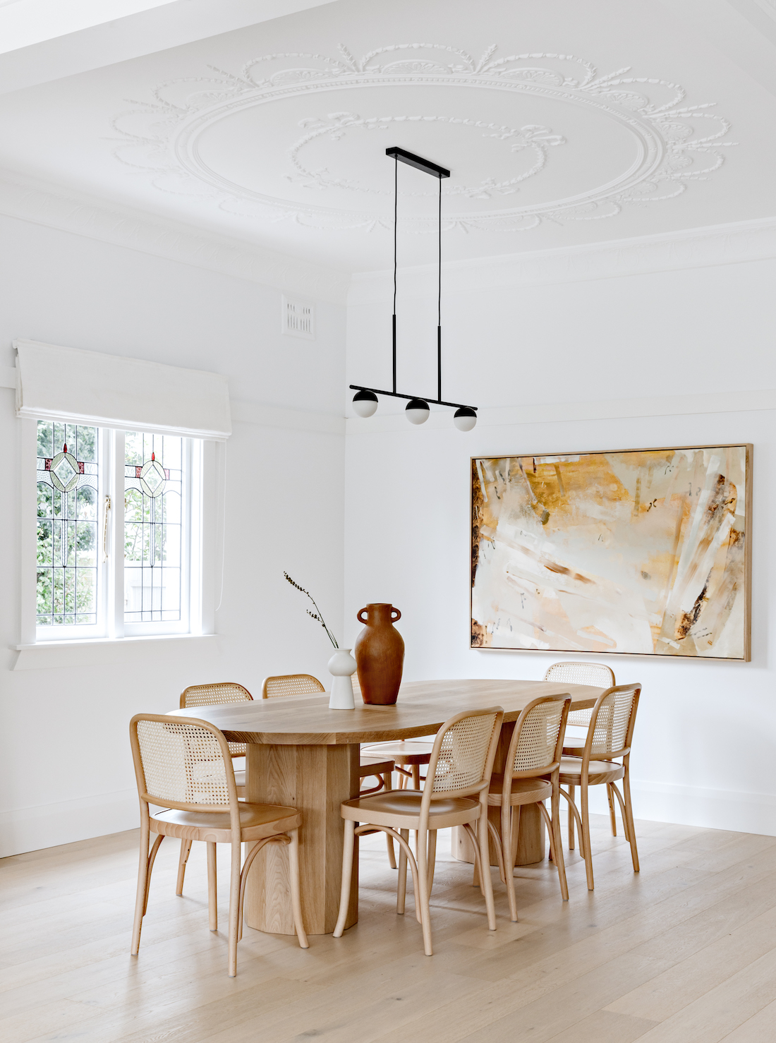 Dining room with pendant light and large artwork