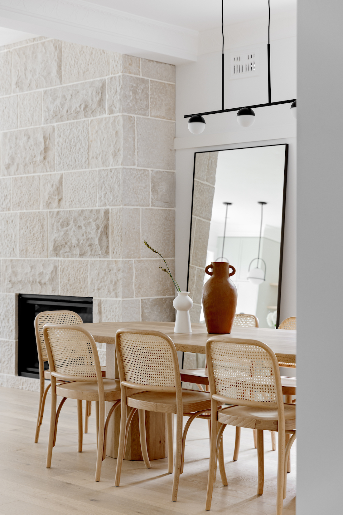 Rattan dining chairs with stone fireplace