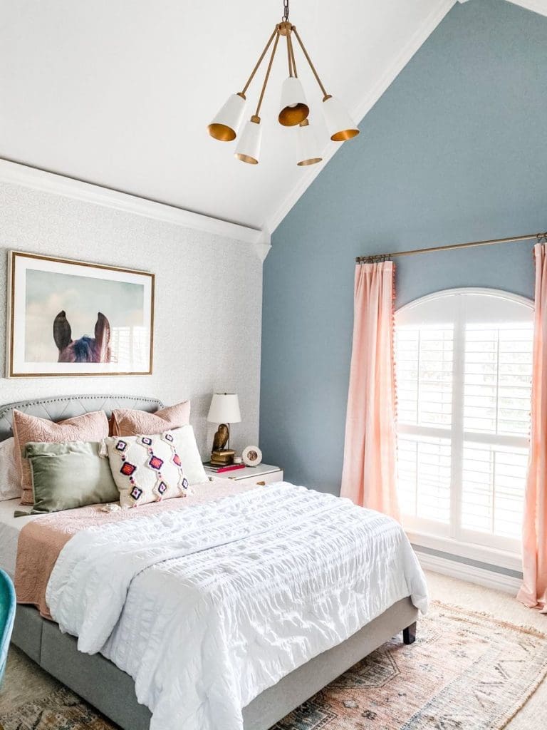 Powder blue feature wall and pink curtains in a sophisticated tween bedroom