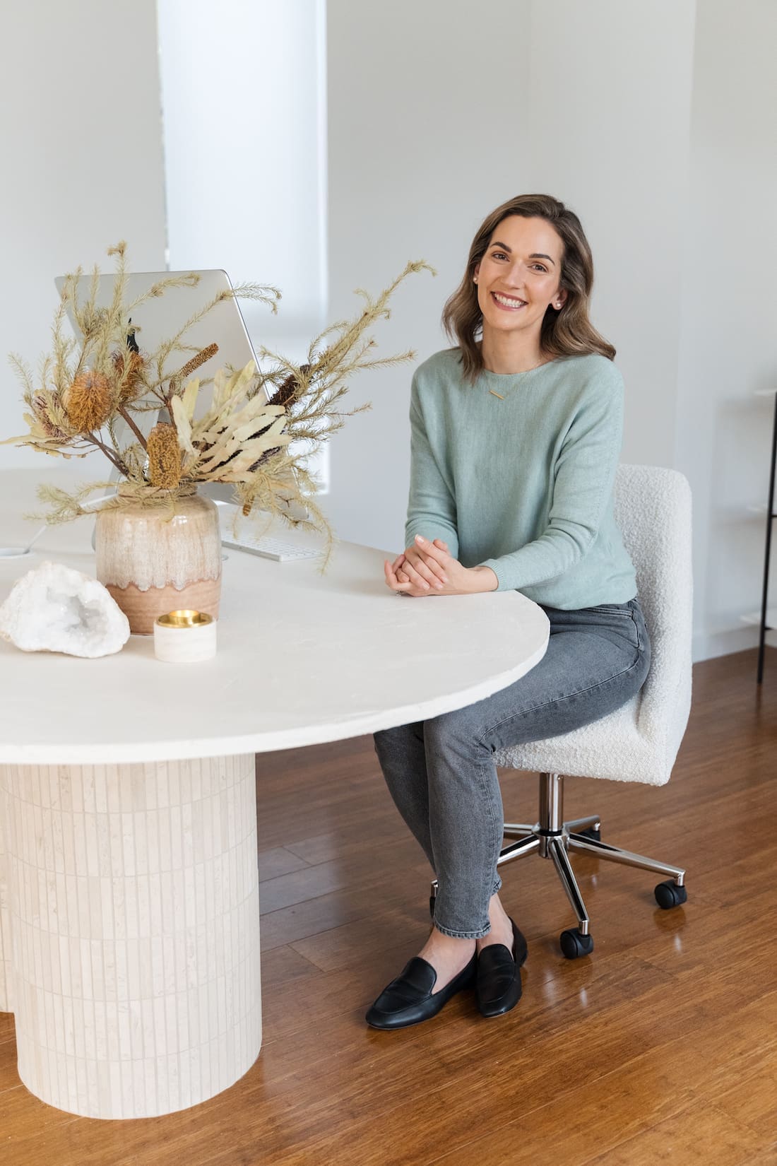 Gina of Style Curator sitting at DIY travertine table