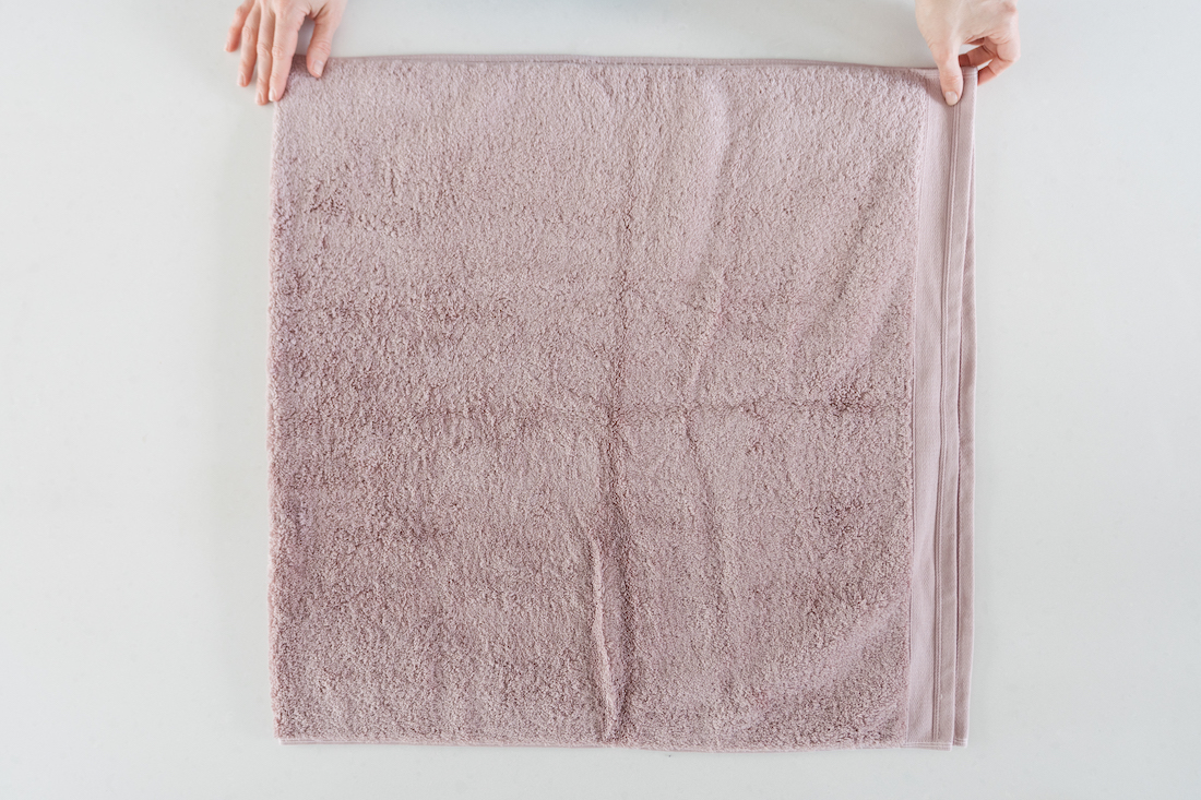 Fold the towel in half lengthwise