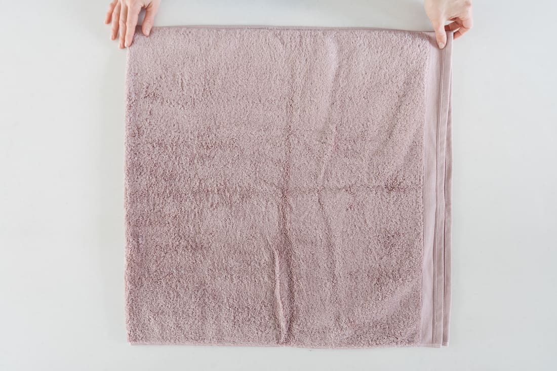 https://stylecurator.com.au/wp-content/uploads/2022/08/Elevated-fold_step-1-fold-towel-in-half.jpg