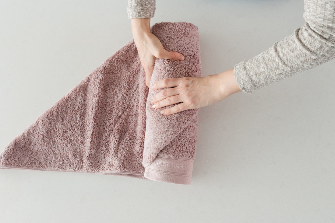How to roll a towel for packing (step-by-step).
