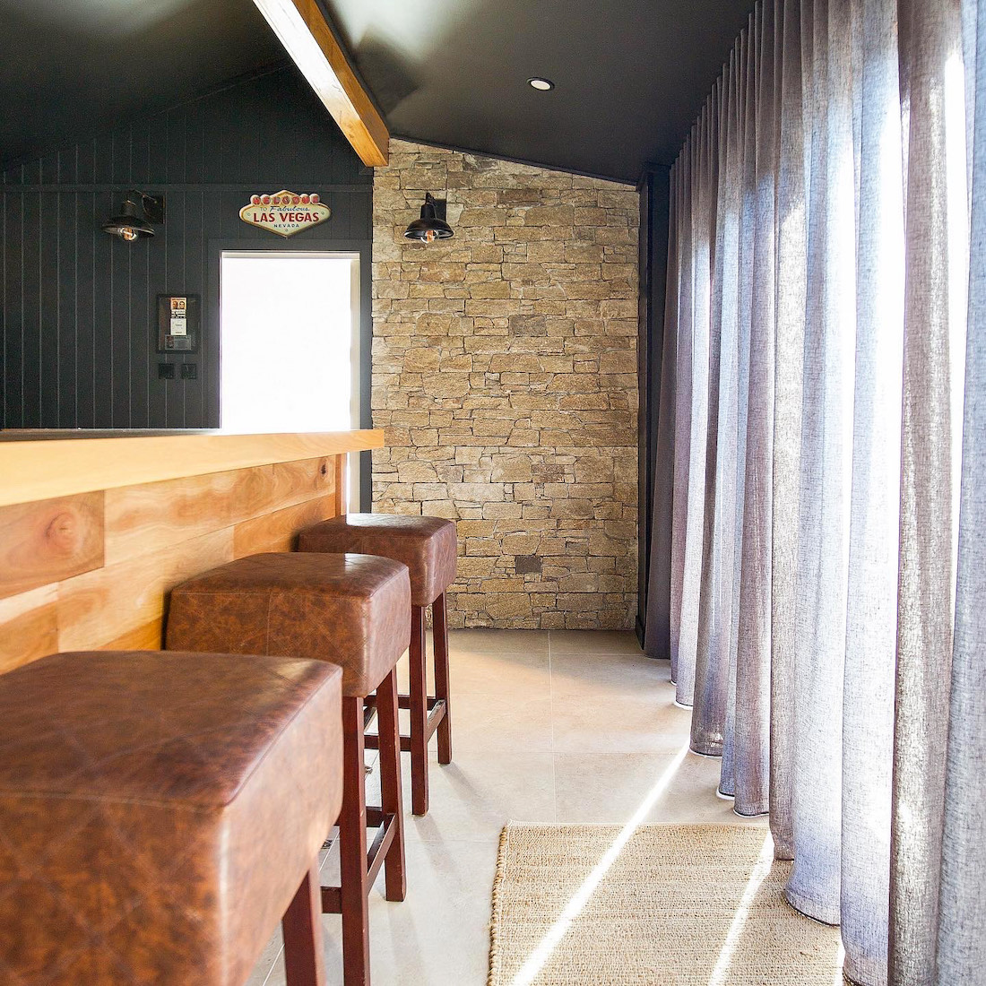 Leather stools and stone wall in man cave