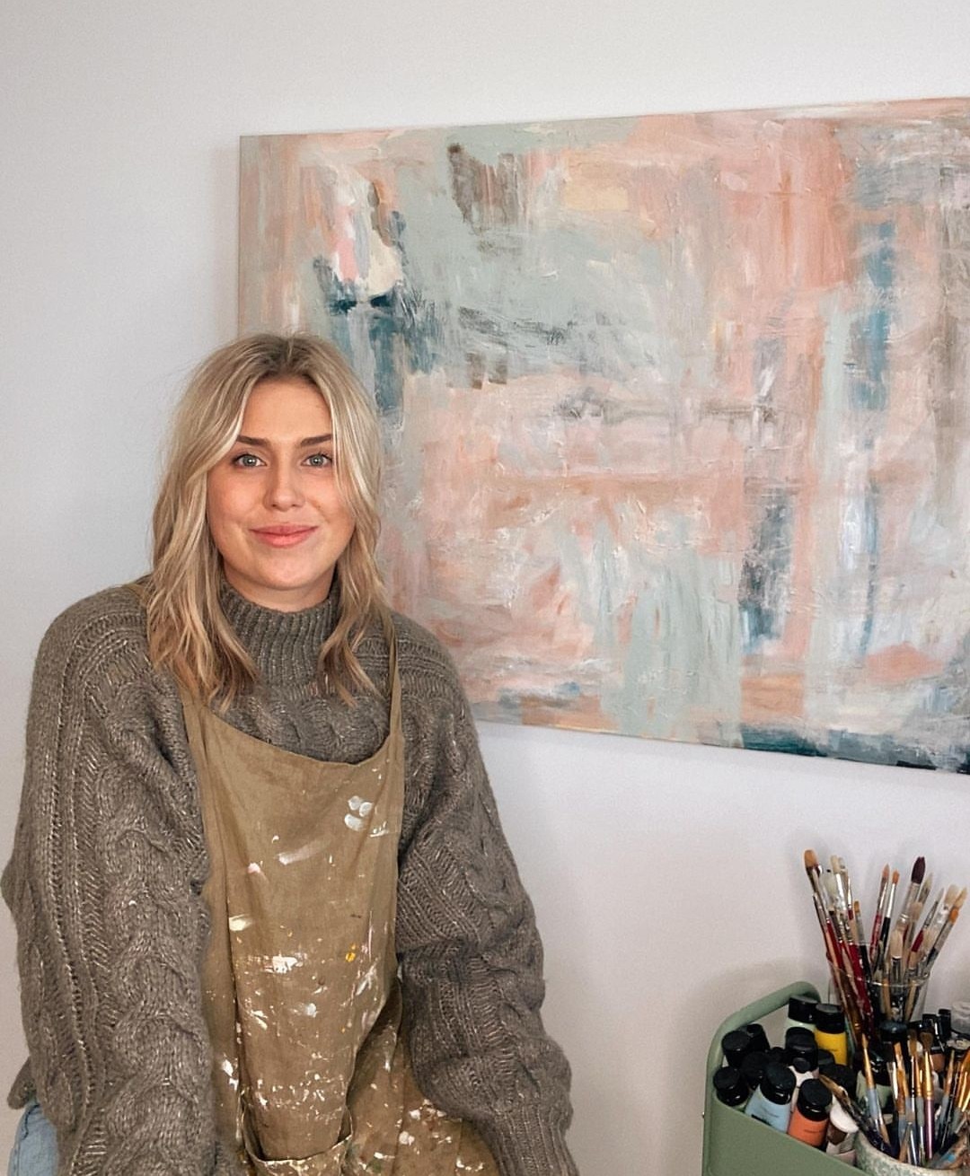 Ally S next to one of her paintings