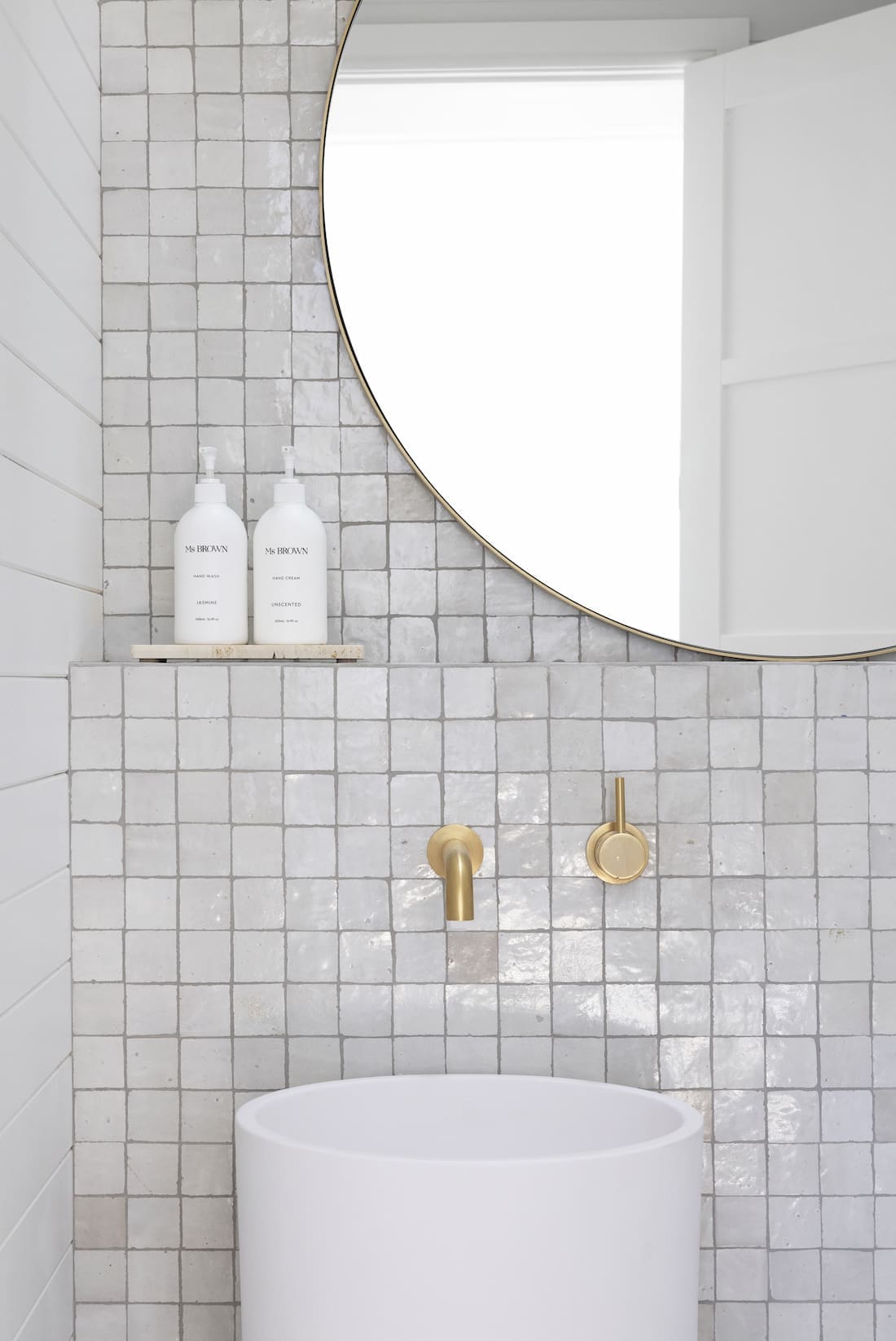 Square tiles in white and grey bathroom with gold taps