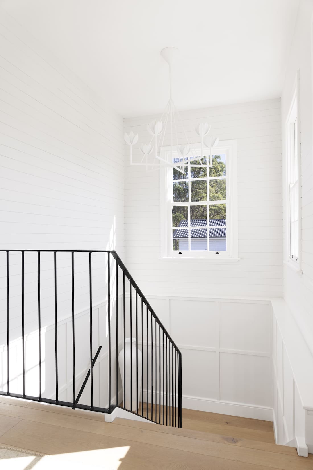 White hallway with black railing