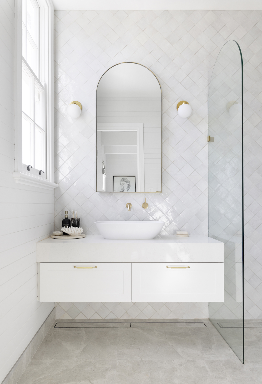White bathroom with arch mirror from Studio Haus Co