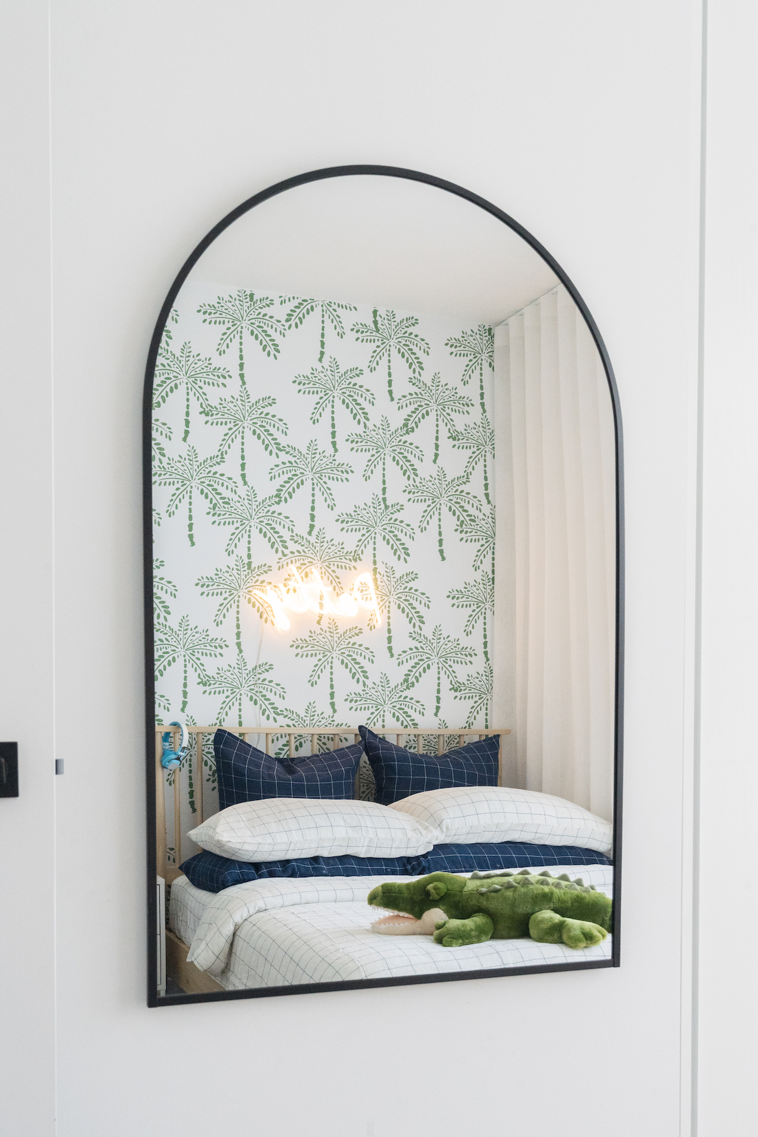 Arch mirror reflection adds contemporary element to boy's bedroom design