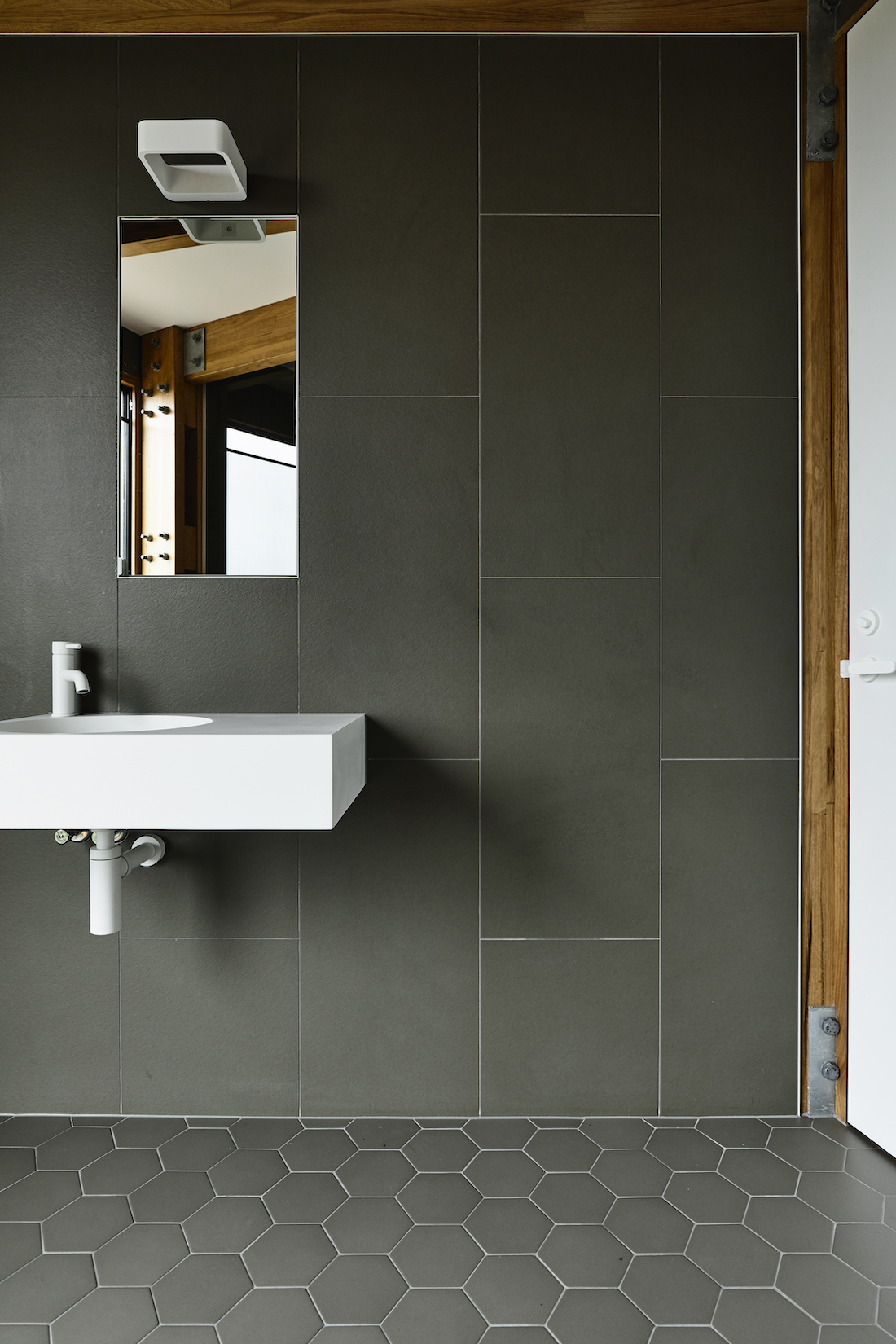 Grey wall tiles with white tap and vanity in bathroom