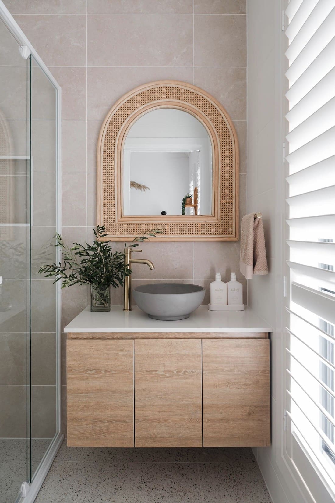 Curved rattan mirror in ensuite bathroom