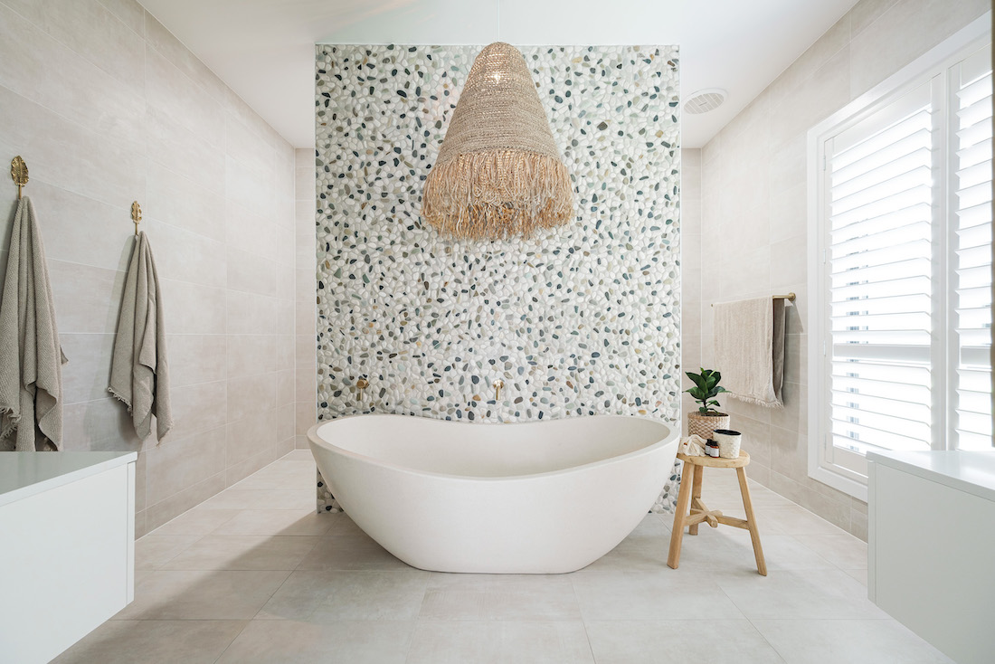 Pebble wall in master bathroom with basket pendant