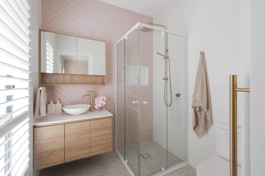 Feminine ensuite bathroom with pink herringbone tiles