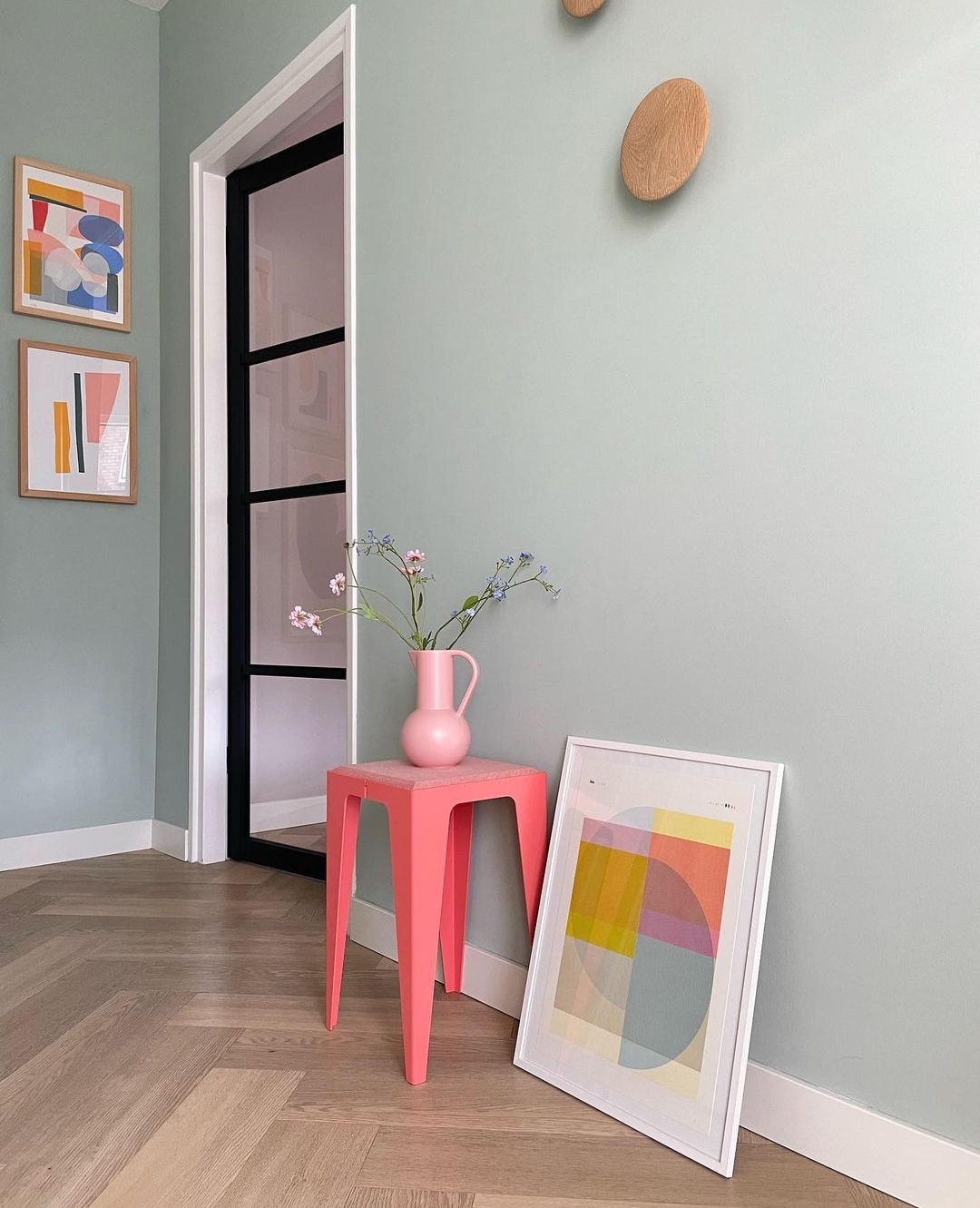 Blue green walls with pink stool in hallway