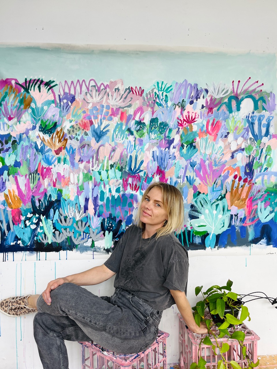Anna Price in her studio in front of a large abstract artwork