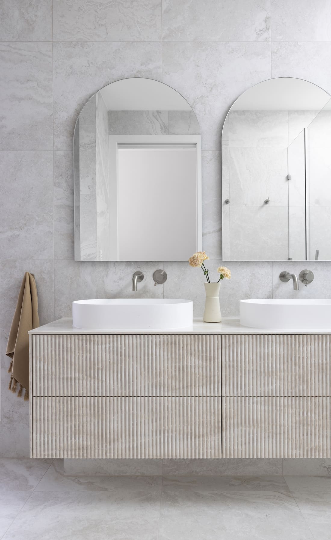 Bathroom with textured cabinetry and double arch mirrors