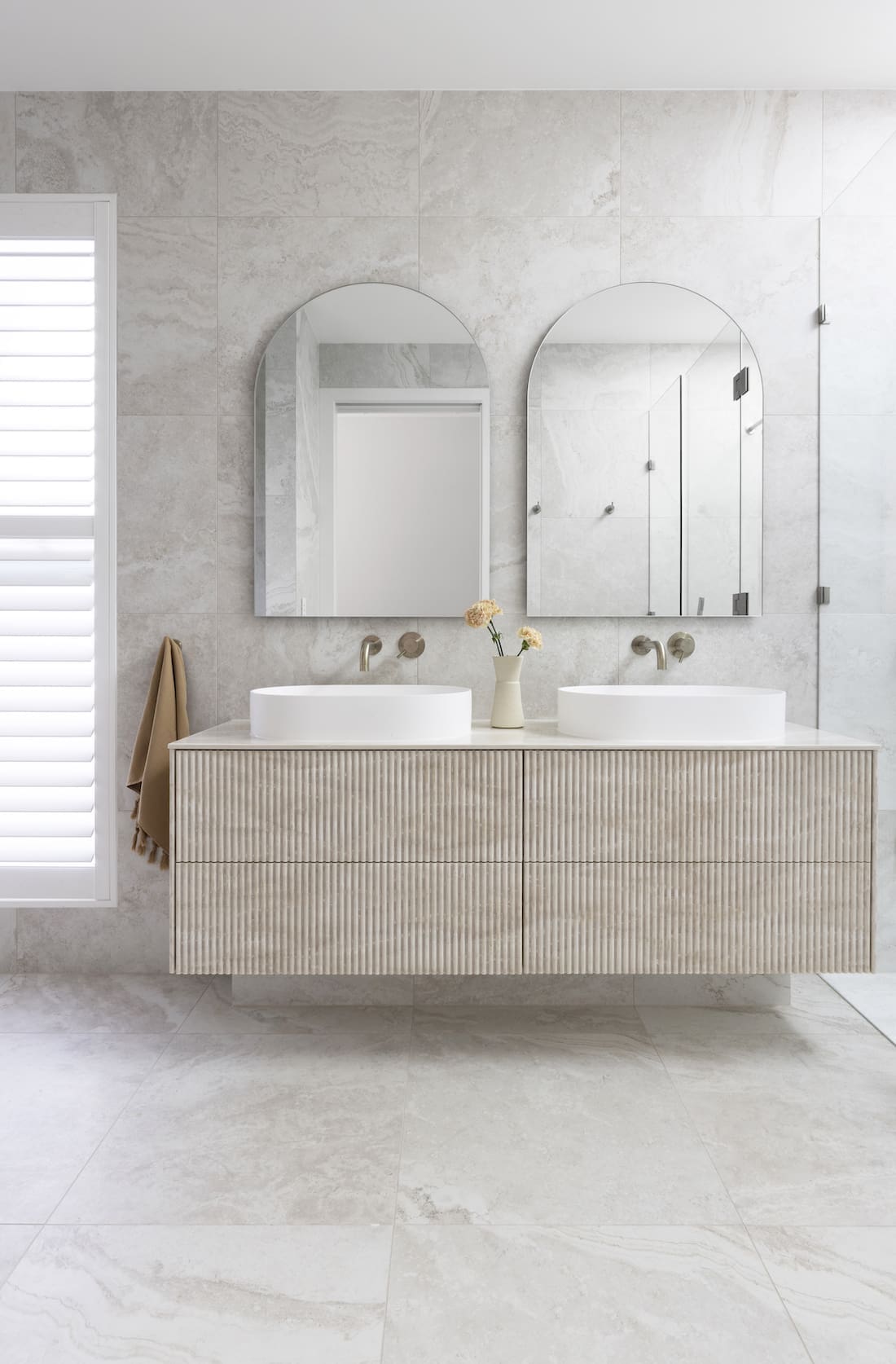 Bathroom with textured cabinetry and double arch mirrors