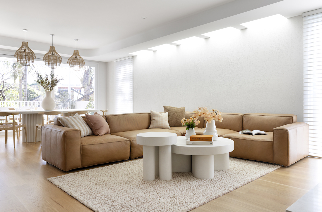 Living room with extra large tan sofa and custom curved coffee tables