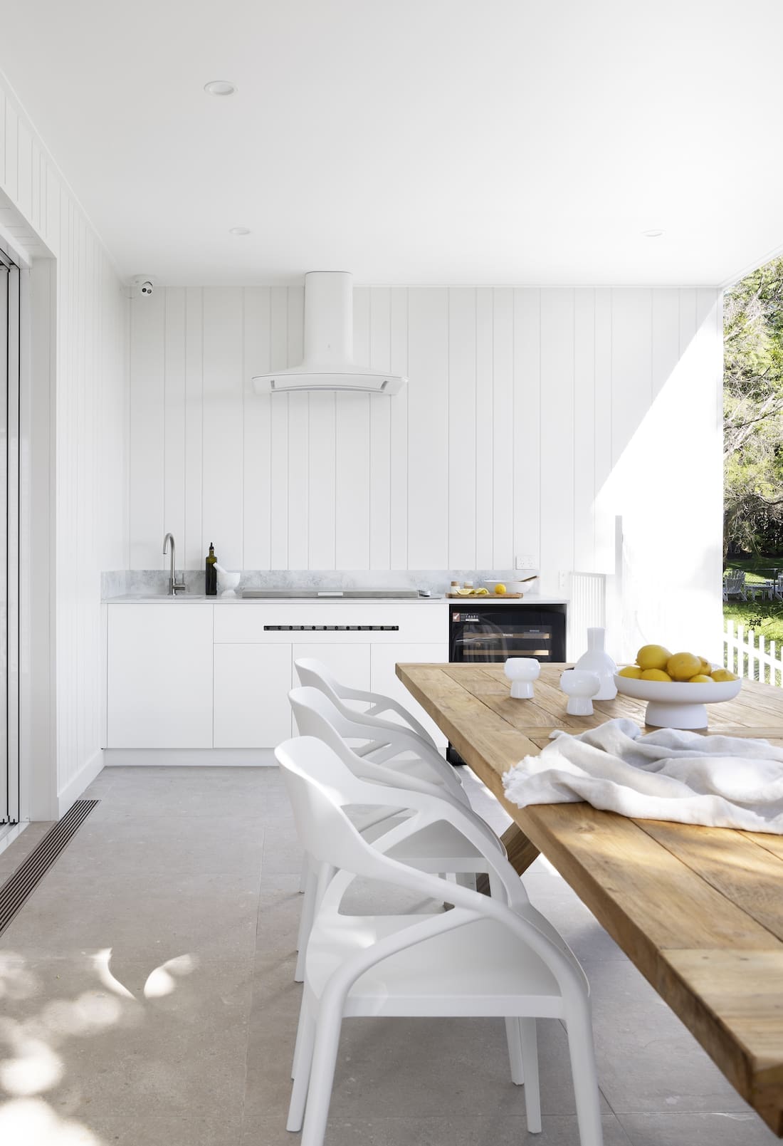 Exterior deck with dining table and outdoor kitchen