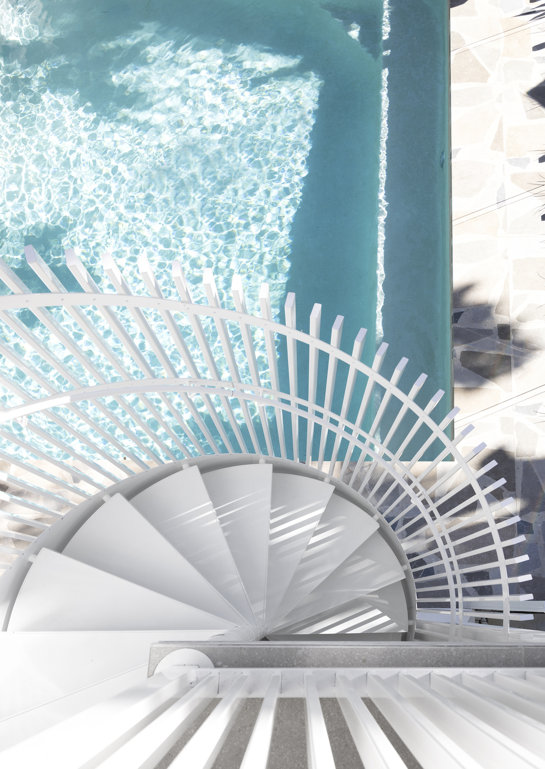 White spiral staircase to pool area