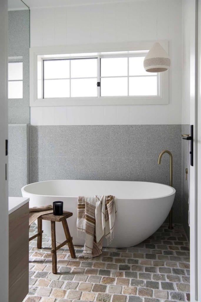 Standalone bath with cobblestone flooring