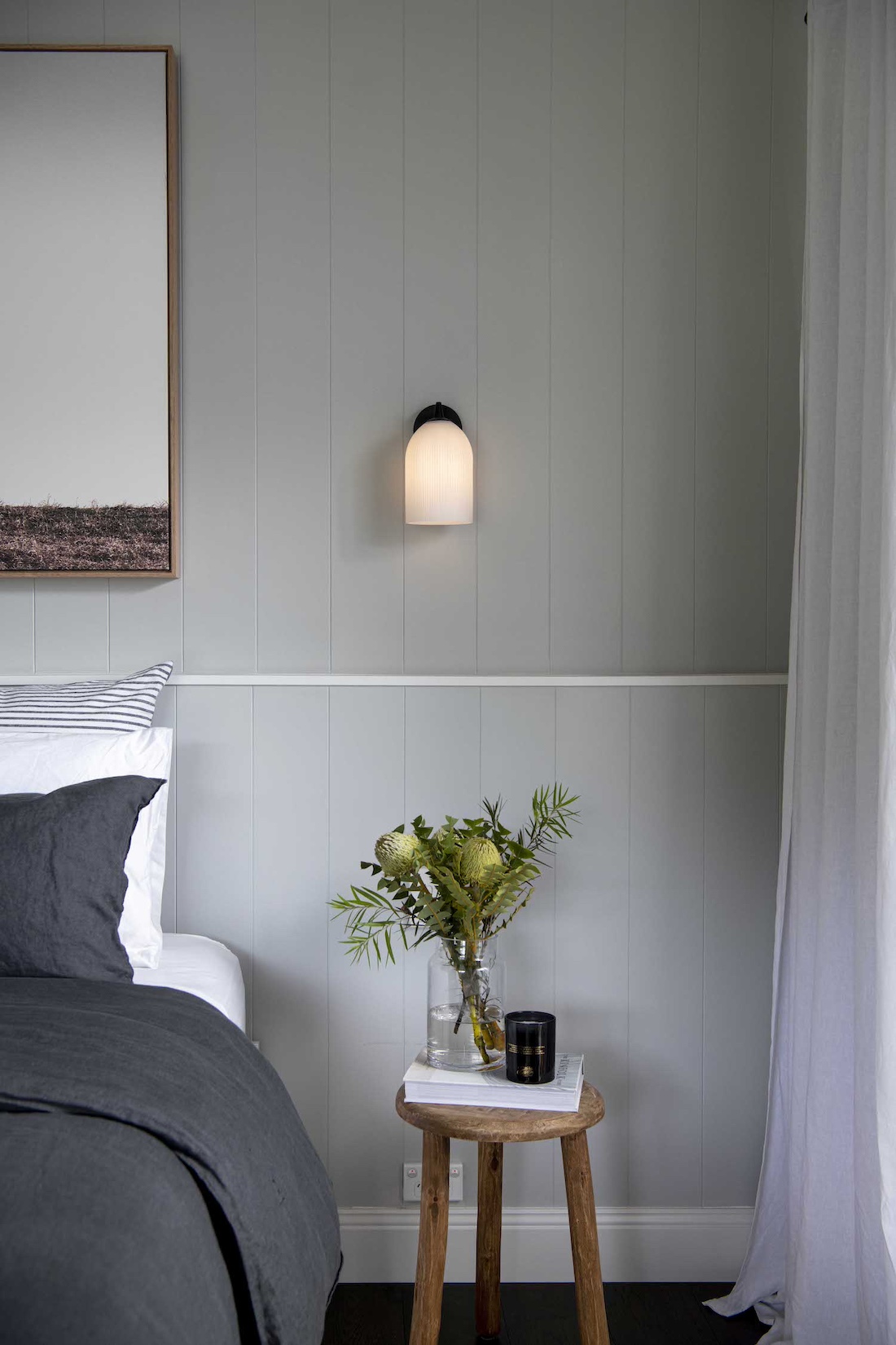 Grey wall in bedroom with small timber side table