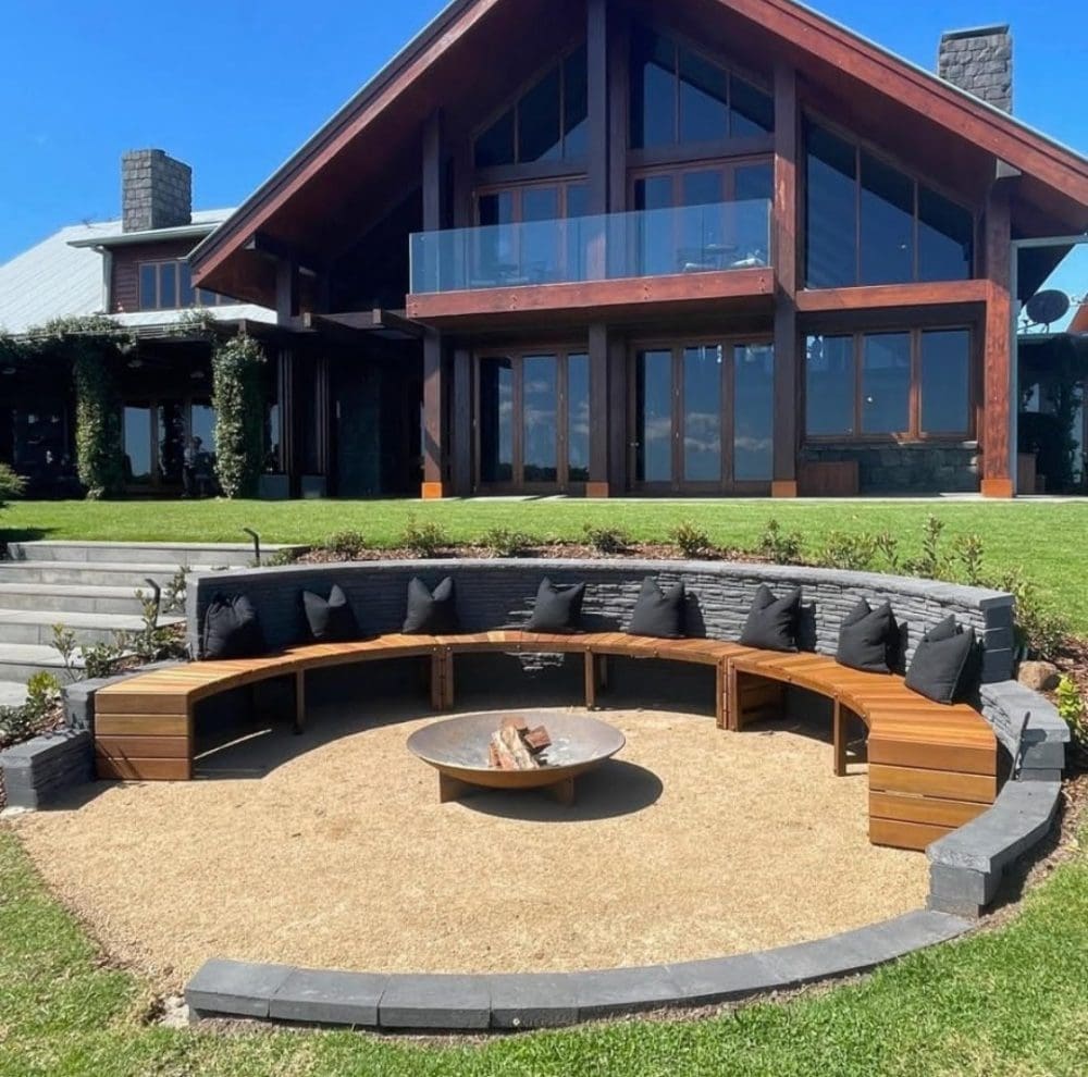 Firepit with dark timber house in the background