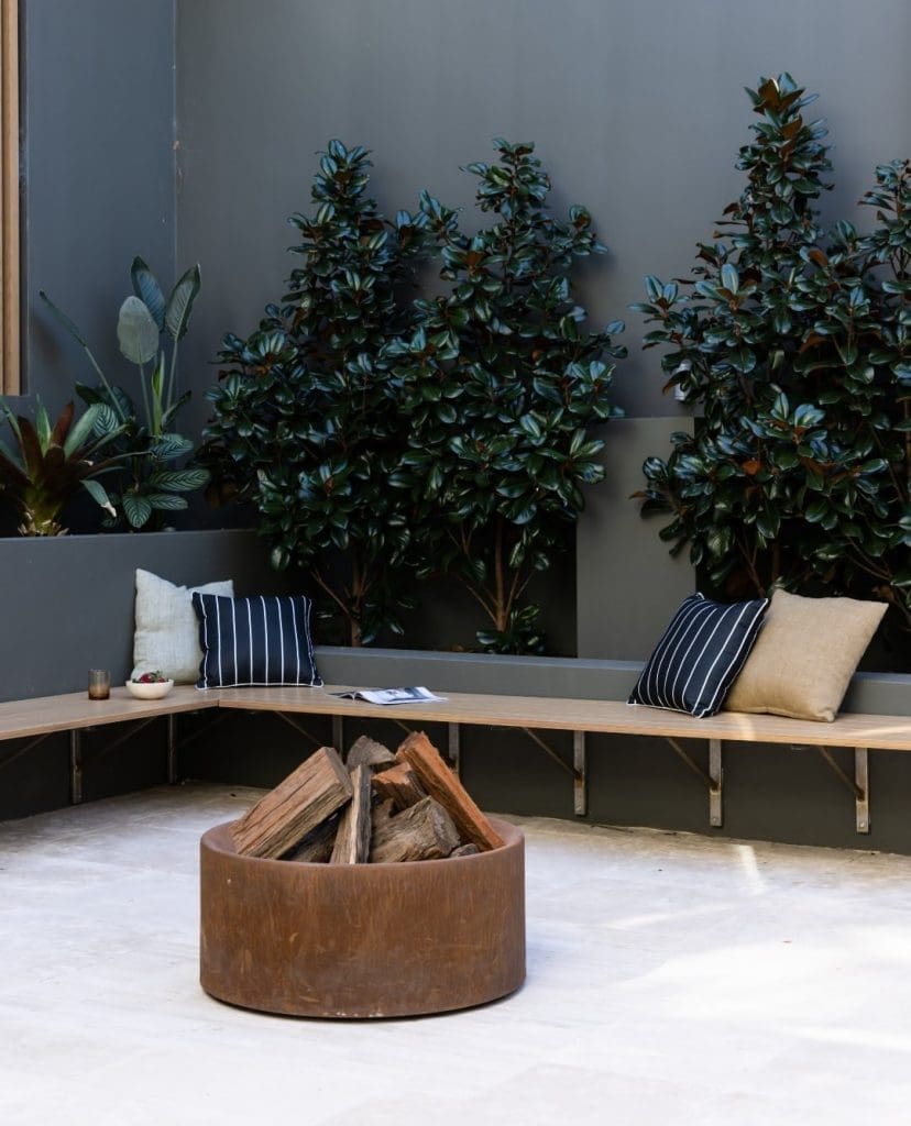 Round firepit with lilly pilly behind benchseat