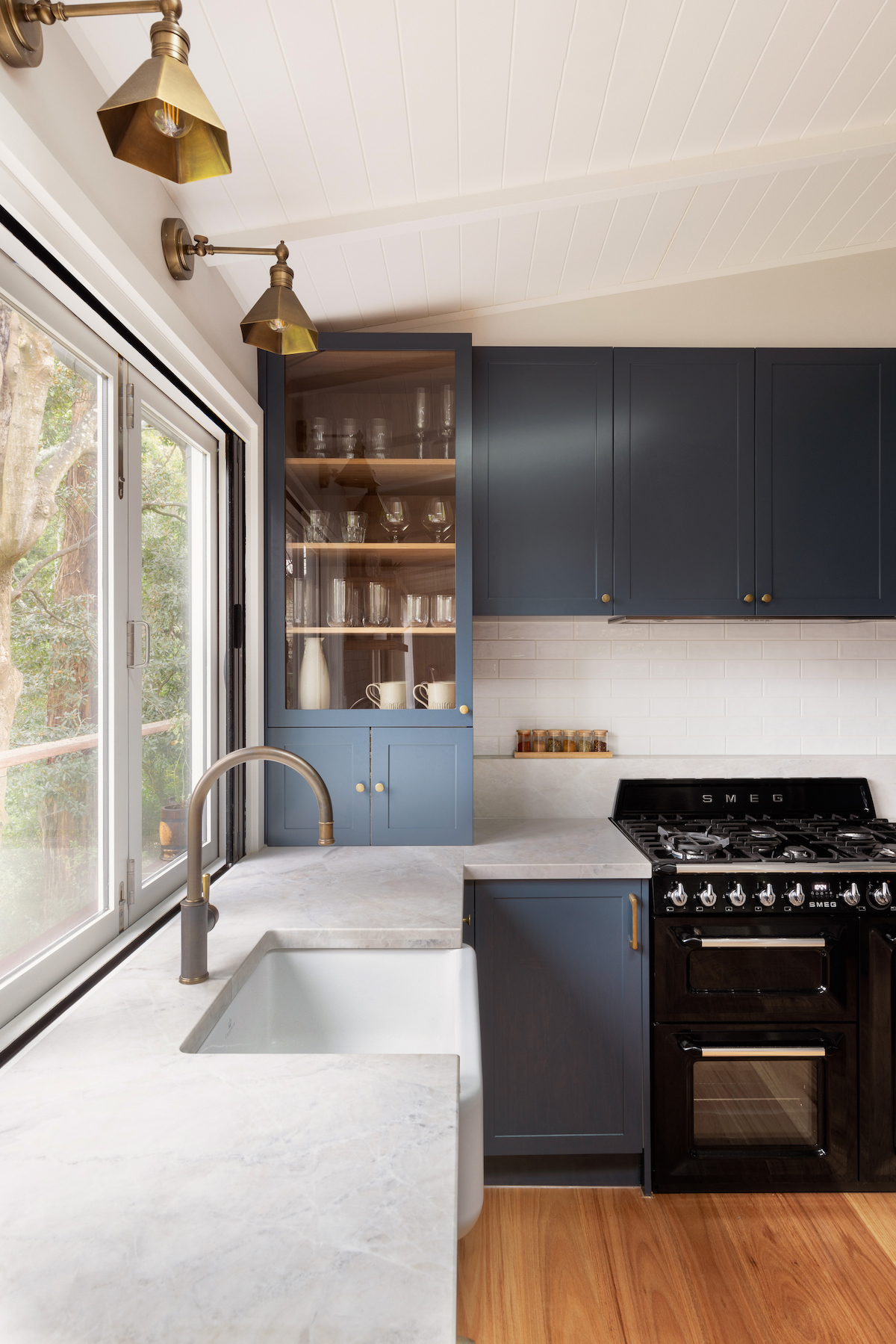 Traditional wall lights above kitchen sink in farmhouse meets contemporary style kitchen